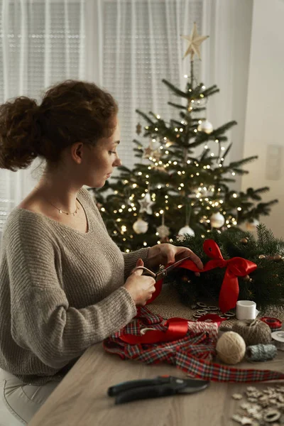 若い白人女性クリスマスリースを作る — ストック写真