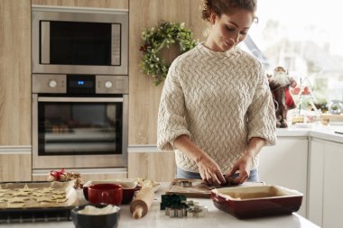 Kızıl saçlı kadın Noel kurabiyeleri için hamur hazırlıyor.