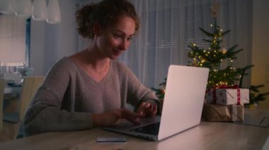 Genç beyaz kadın dijital dizüstü bilgisayar kullanarak online alışveriş yapıyor. 8K 'da kırmızı helyum kamerayla çekildi..  