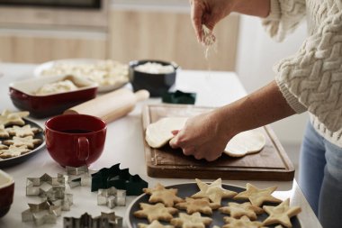 Tanınmayan bir kadın Noel kurabiyeleri için hamur hazırlıyor.