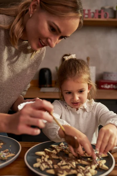 母亲和女儿用巧克力装饰姜汁 — 图库照片