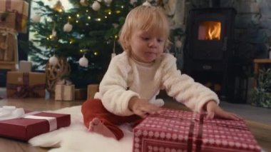 Beyaz çocuk, Noel hediyesini açıyor. 8K 'da kırmızı helyum kamerayla çekildi..  