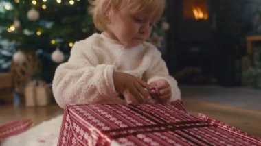 Kafkasyalı küçük çocuğun Noel hediyesini açmasına yakın çekim. 8K 'da kırmızı helyum kamerayla çekildi.. 