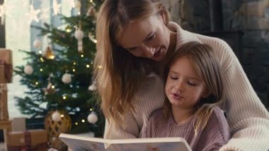 Anne ve kızı Noel zamanı kitap okuyorlar. 8K 'da kırmızı helyum kamerayla çekildi.. 
