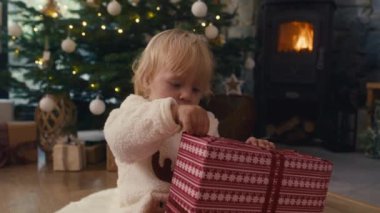 Beyaz çocuk, Noel hediyesini açıyor. 8K 'da kırmızı helyum kamerayla çekildi..  