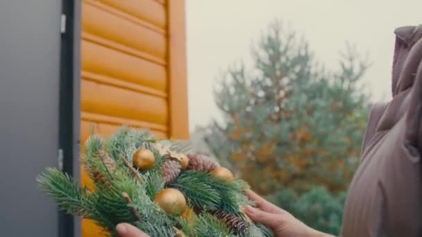 Blanke Vrouw Die Kerstkrans Aan Deuren Hangt Opgenomen Met Red — Stockvideo