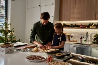 Beyaz baba ve kız evcil mutfakta zencefilli ekmek yapıyorlar.