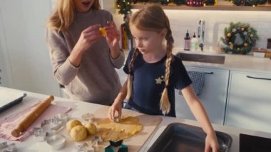 Kafkas anne ve kızının ev mutfağında zencefilli ekmek yaptığı yüksek açılı bir manzara. 8K 'da kırmızı helyum kamerayla çekildi..   