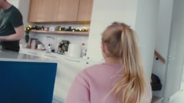 白人女孩跑进厨房 父母在圣诞节前正在厨房做饭 用8K的红色氦相机拍摄 — 图库视频影像