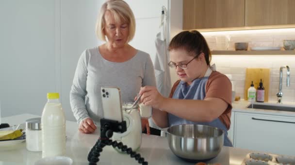 ダウン症の女性と彼女の母親はキッチンで一緒にベーキング 8KでRedヘリウムカメラで撮影する — ストック動画