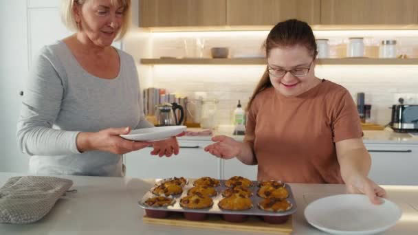 ダウン症の女性と母親は自家製のカップケーキを食べようとしています 8KでRedヘリウムカメラで撮影する — ストック動画