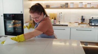 Down sendromlu kadın evdeki mutfağı temizliyor. 8K 'da kırmızı helyum kamerayla çekildi.. 