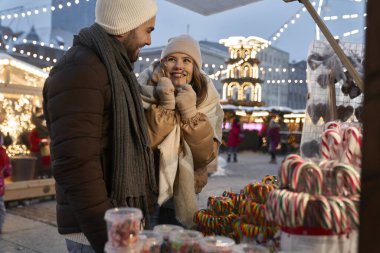 Kafkasyalı çift geceleri Noel pazarından şeker alıyor.