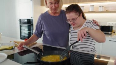 Down sendromlu kadın ve annesi birlikte kahvaltı hazırlıyorlar. 8K 'da kırmızı helyum kamerayla çekildi..    