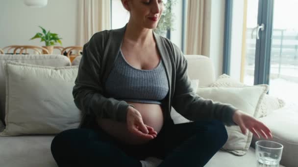 Καυκάσια Έγκυος Γυναίκα Που Κάθεται Στον Καναπέ Και Λαμβάνει Συμπληρώματα — Αρχείο Βίντεο