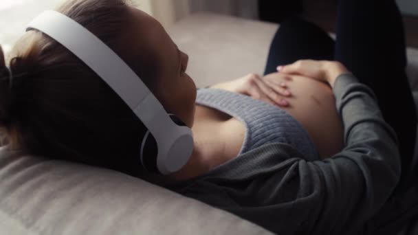 Widok Ciężarnej Kobiety Leżącej Kanapie Słuchającej Muzyki — Wideo stockowe