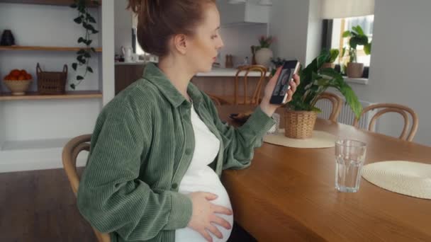 Mujer Embarazada Sentada Junto Mesa Recibiendo Videollamadas Con Médico — Vídeo de stock