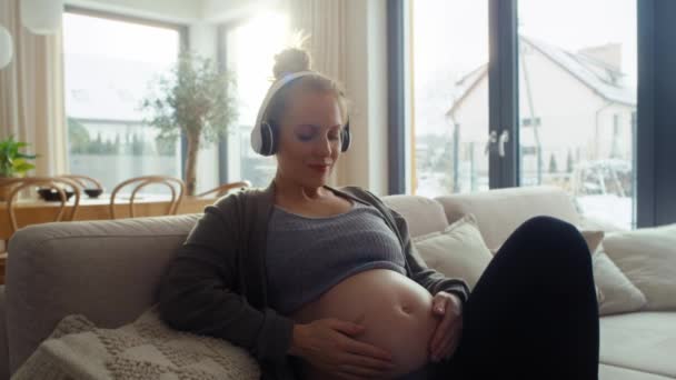 Kavkazská Těhotná Žena Ležící Pohovce Poslouchající Hudbu — Stock video