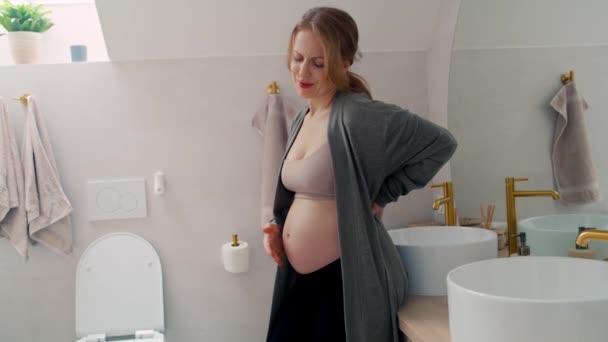 バスルームに立っている間 白人女性が腰痛を感じる — ストック動画