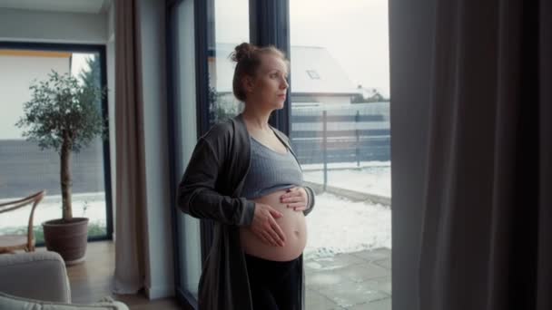 Αγχωμένη Έγκυος Γυναίκα Στέκεται Δίπλα Στο Παράθυρο Και Αγγίζει Την — Αρχείο Βίντεο