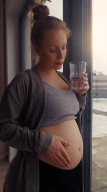 Karnına dokunan endişeli hamile kadının dikey videosu.