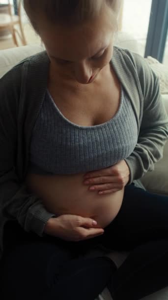 Pionowe Wideo Białej Kobiety Ciąży Siedzącej Kanapie Dotykającej Jej Brzucha — Wideo stockowe