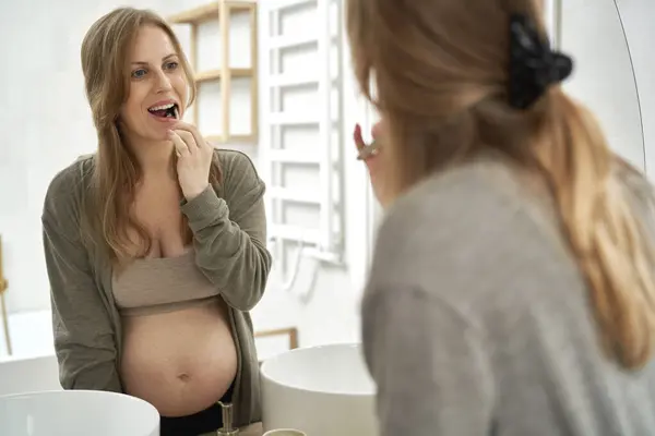 怀孕妇女在浴室刷牙 — 图库照片