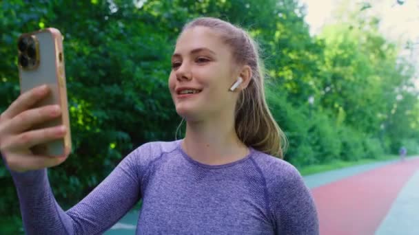 Žena Sportovním Oblečení Trati Mluví Přes Mobilní Telefon Utíká — Stock video