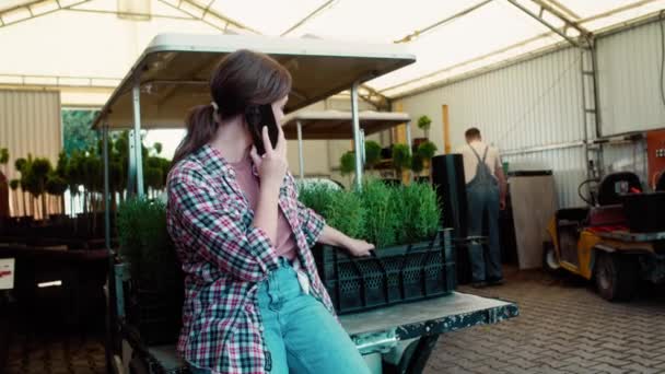 温室で携帯電話を使った白人女性植物学者 8KでRedヘリウムカメラで撮影する — ストック動画