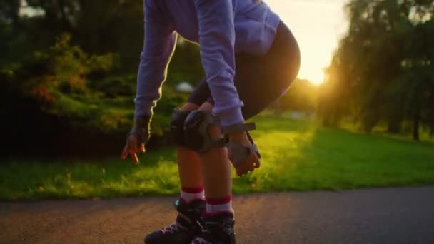 日没の間に公園で認識できない若い女性のローラーブレード — ストック動画