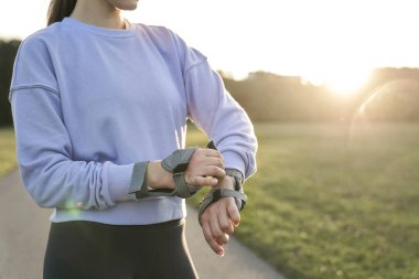 Genç bayan parkta paten kaymaya hazırlanıyor.