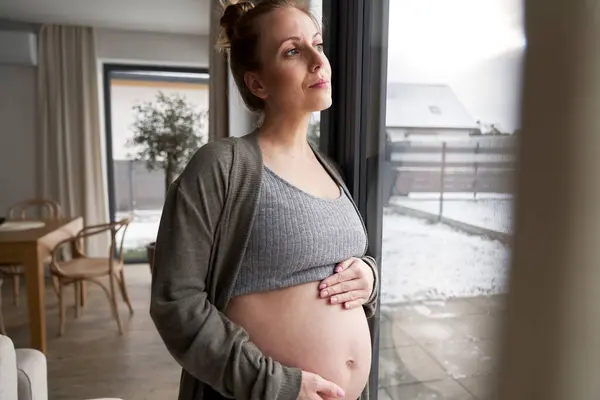 Anxious Pregnant Woman Standing Next Window Touching Her Abdomen — Stock Photo, Image