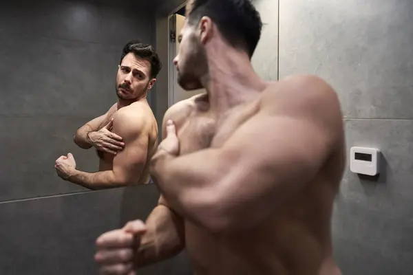 白人男人检查镜子里的肌肉 — 图库照片