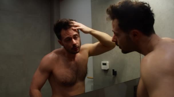 浴室で髪の状態をチェックする白人男性 — ストック動画