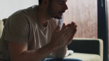 Evdeki kanepede endişeli bir adam.