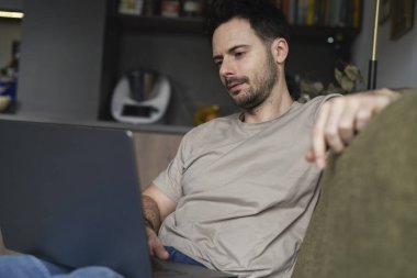 Kanepede Dizüstü bilgisayarda çalışan adam