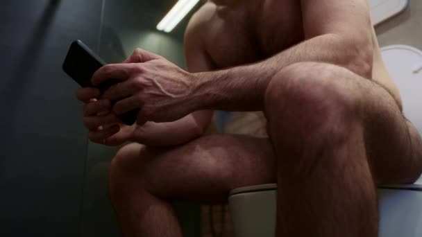 Niski Kąt Widzenia Człowieka Siedzącego Toalecie Przeglądającego Telefon Komórkowy — Wideo stockowe