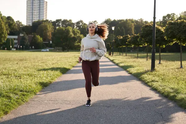 日落时妇女在公园慢跑的全景 — 图库照片