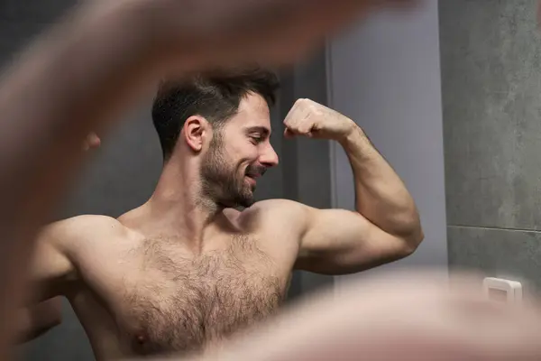 Caucasian Man Flexing Muscles Mirror Stock Photo