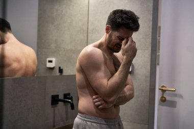 Banyoda sinüsleri ağrıyan bir adam.