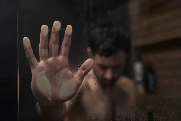 人的手放在淋浴器上 图库照片