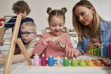 Öğretmen ve çocuklar anaokulunda duyusal egzersizler yapıyorlar.