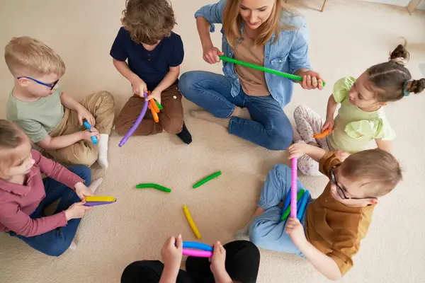 Insegnante Bambini Che Fanno Esercizi Sensoriali Nella Scuola Materna Foto Stock Royalty Free