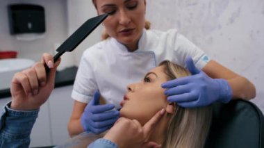 Doktor ve hasta planlı güzellik prosedürünü tartışıyor