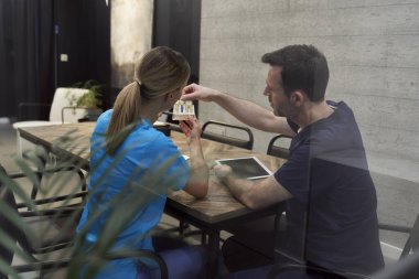 Toplantı odasında iki doktorun diş implantı konferansı var.