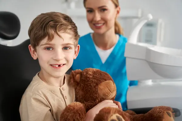 Child Holding Teddy Bear Dentist Office Stock Image