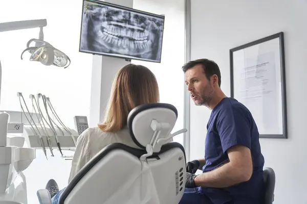 Dişçi Hastanın Dişlerinin Panoramik Dijital Röntgenini Tartışıyor Stok Fotoğraf