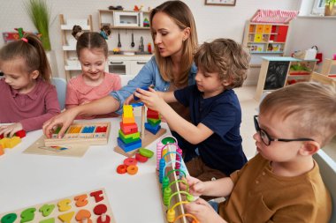 Öğretmen ve çocuklar anaokulunda duyusal egzersizler yapıyorlar.