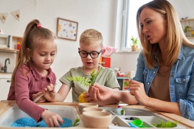 Fizyoterapist çocuklara egzersiz yaptırıyor.