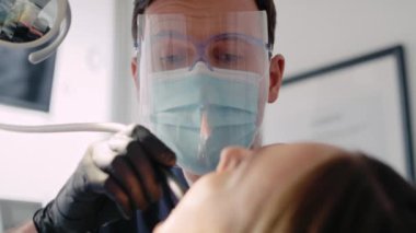 Hastanın dişlerini delen dişçi.